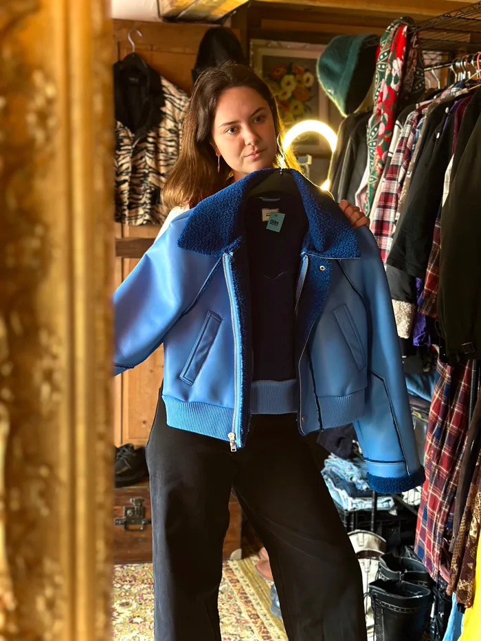 Cliente essayant une veste dans la friperie Neo Vintage
